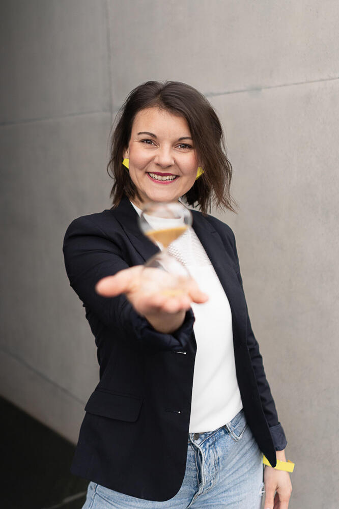 Führungskräfte Coaching München: Romy Möller bietet 1:1 Coaching mit dir als Führungskraft an. Auf dem Bild siehst du sie, wie sie eine Sanduhr in der Hand hält.